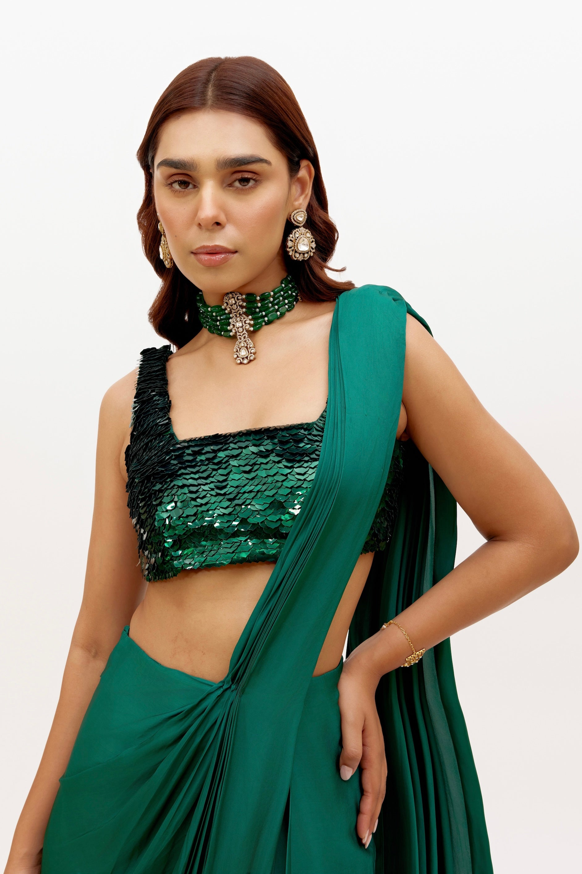 The Raya Drape Saree includes a sequin square-neck blouse and a silky, figure-flattering skirt with an attached drape in a deep, rich emerald color. The attached drape just has to be wrapped around you to complete the look in less than 5 seconds.
