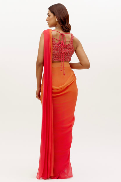 The Mirai Drape Saree showcases a printed ombre skirt with an attached drape that's paired with a hand-embroidered blouse adorned with pearl and sequin detailing. The back of the blouse has beaded tassels for added fun.