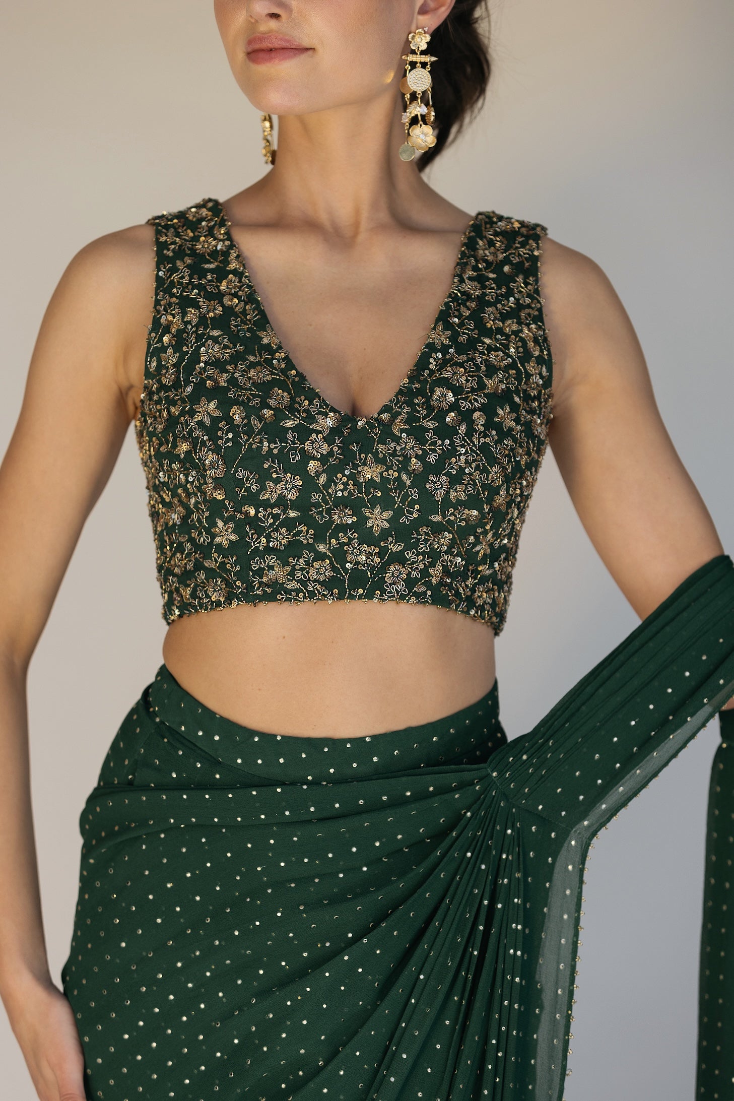 This saree has a hand-embroidered cropped top with intricate beadwork and lustrous sequins and is paired with a skirt featuring attached wraparound draping.