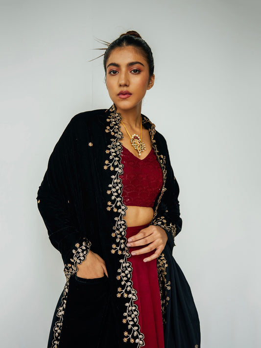Woman wearing velvet embroidered shawl over embroidered red lehenga